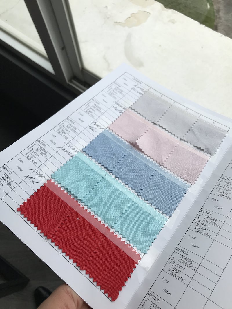 Fabric swatches on a color fastness test sheet after washing