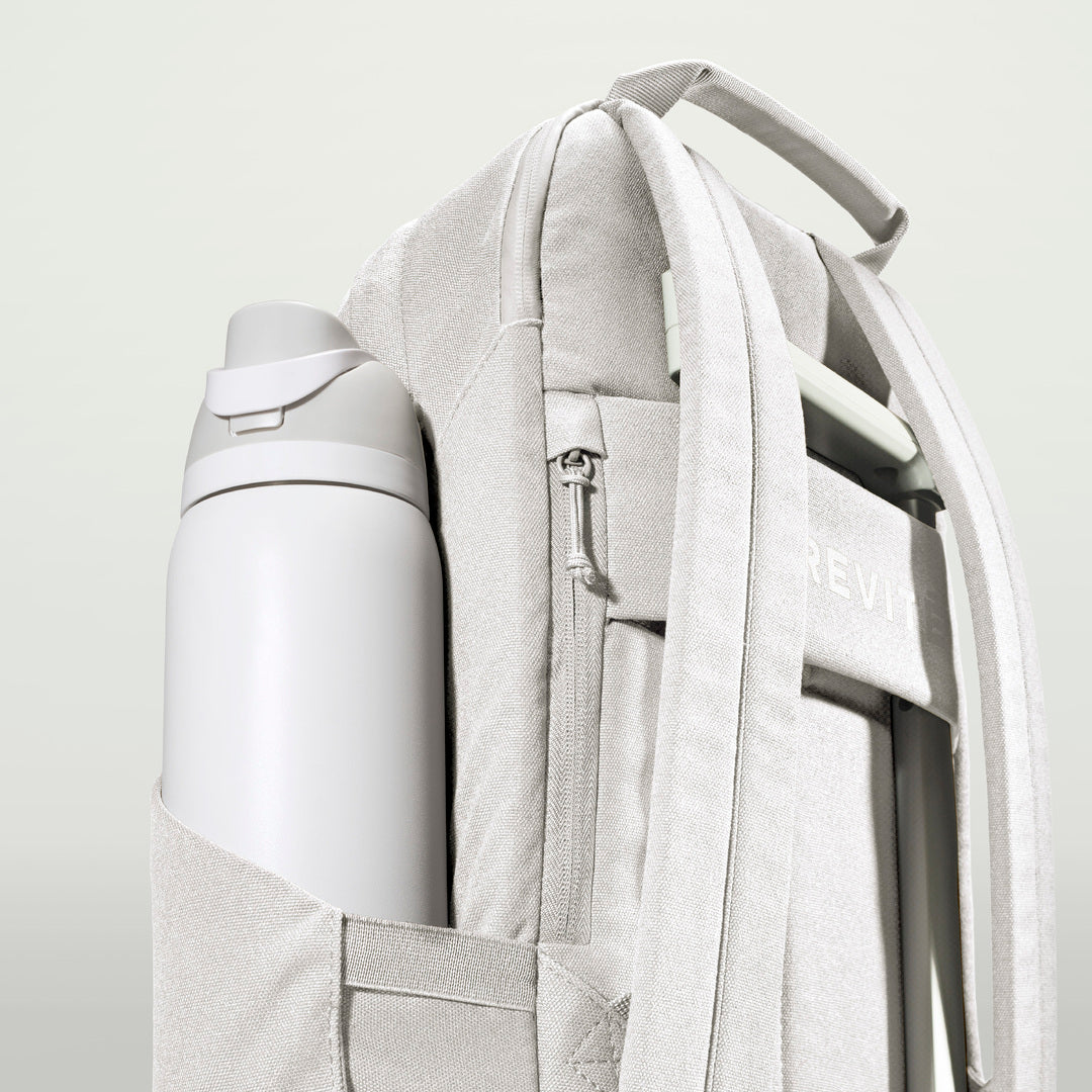 The Brevitē Backpack in Nimbus Gray, large water bottle in the side pocket