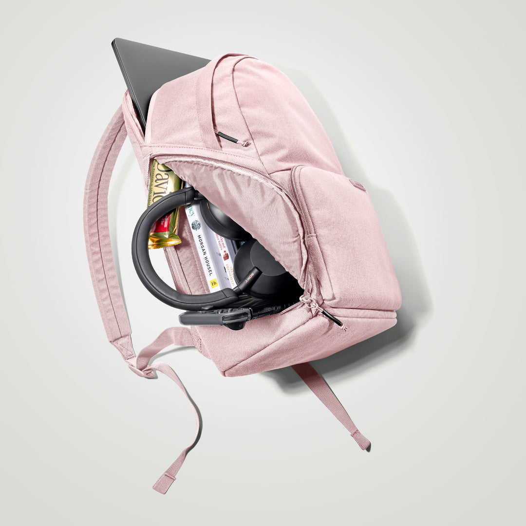 The Brevitē Backpack in Blush Pink, open and packed with a laptop and everyday things
