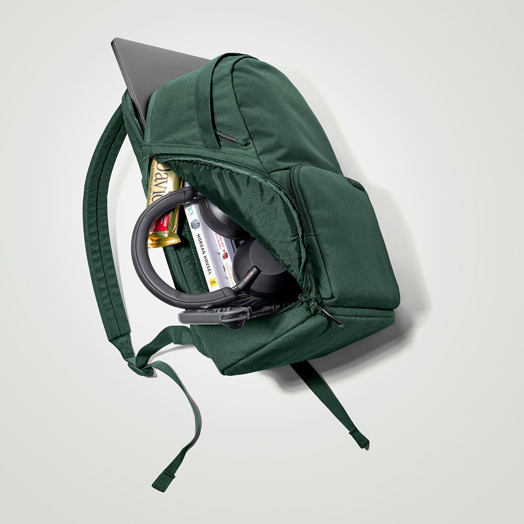 The Brevitē Backpack in Jade Green, open and packed with a laptop and everyday things