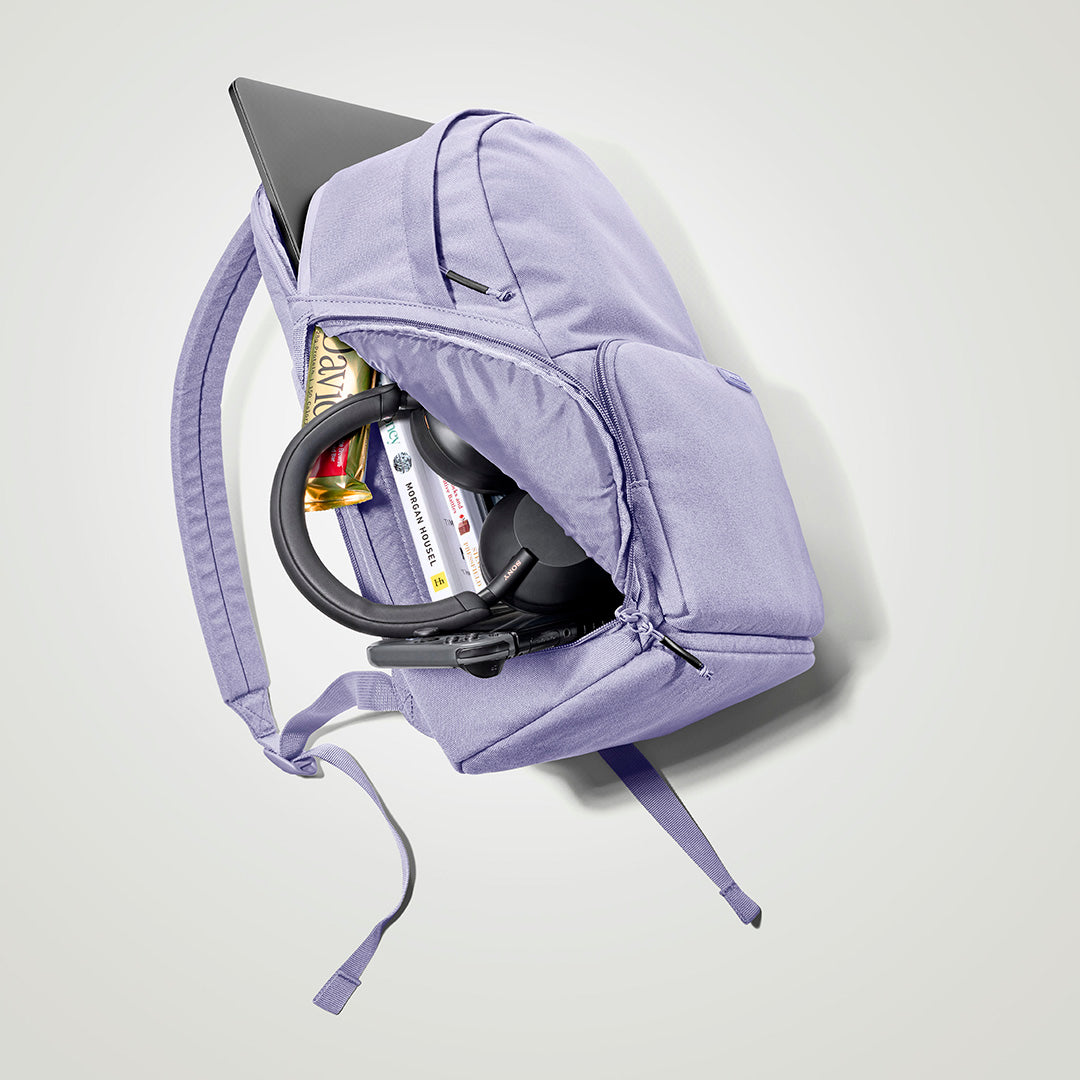 The Brevitē Backpack in Lavender Dream, open and packed with a laptop and everyday things