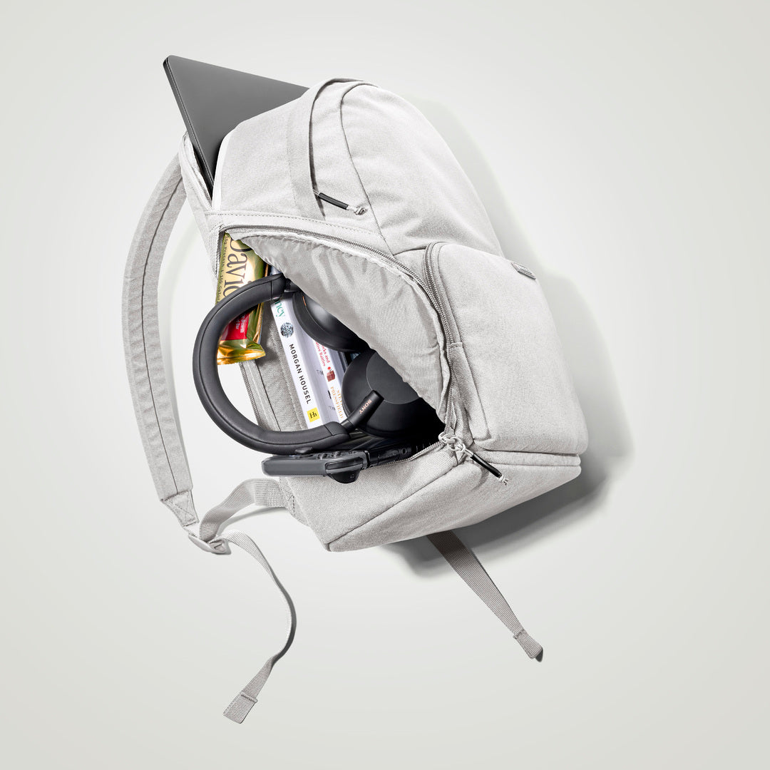 The Brevitē Backpack in Nimbus Gray, open and packed with a laptop and everyday things