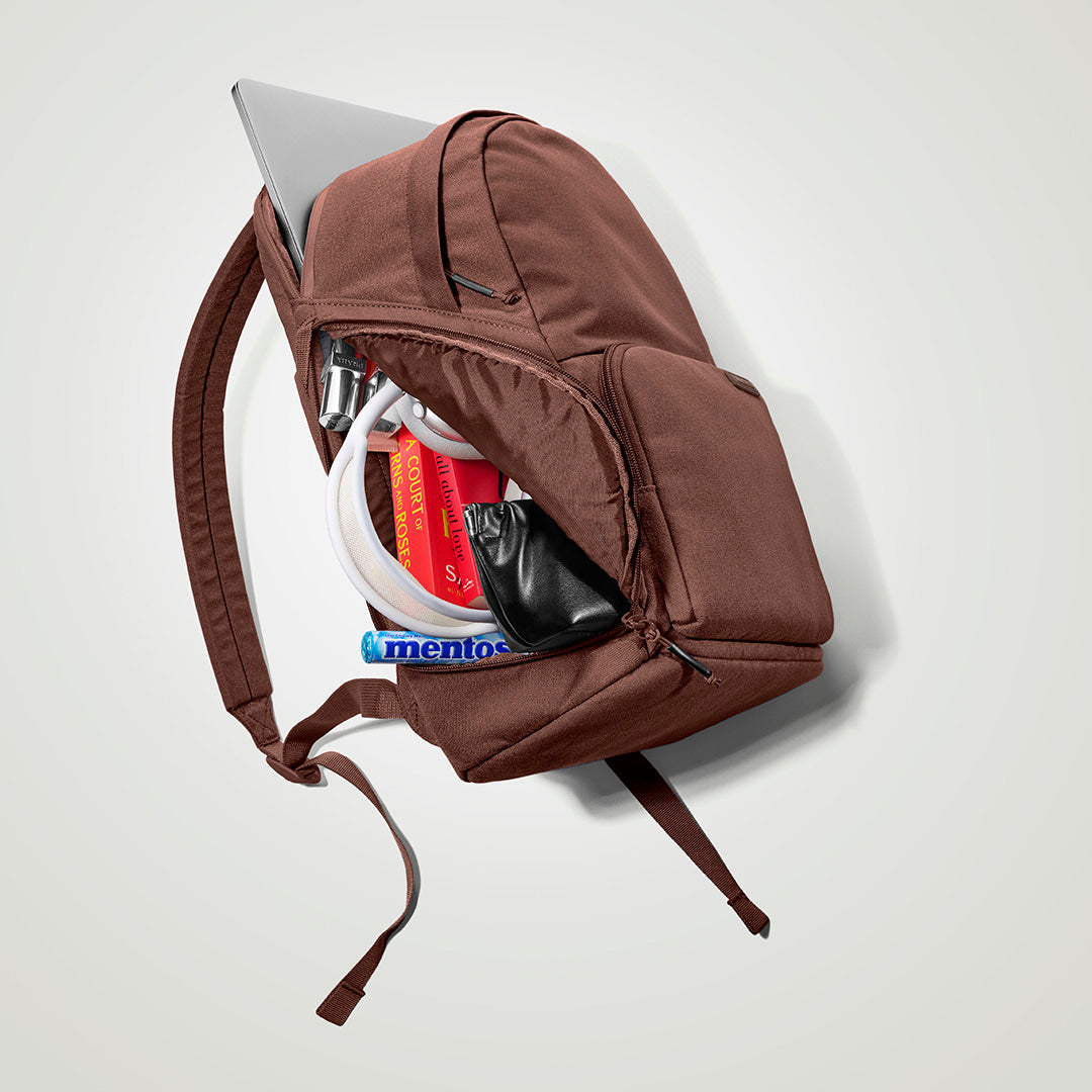 The Brevitē Backpack in Burnt Brown, open, showing the pockets