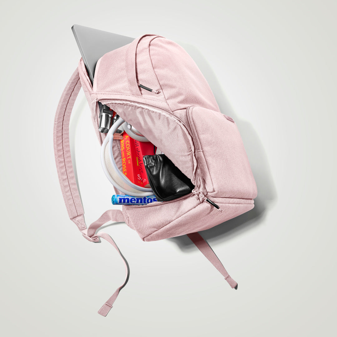 The Brevitē Backpack in Blush Pink, open, showing the pockets