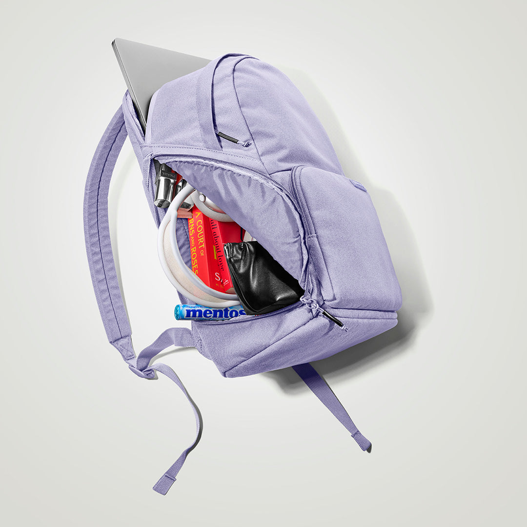 The Brevitē Backpack in Lavender Dream, open, showing the pockets